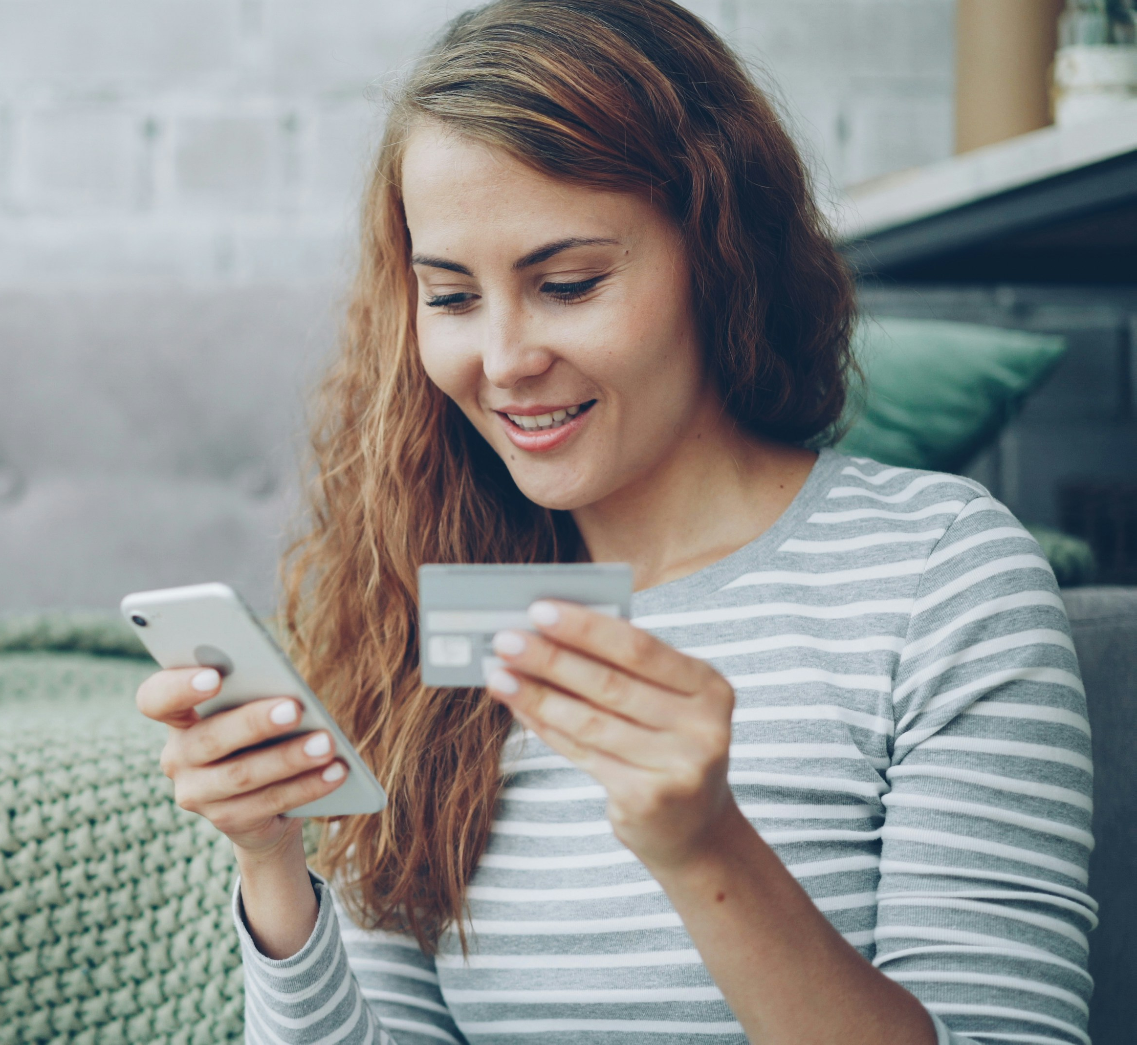 Person using a smartphone and credit card to make an online donation.